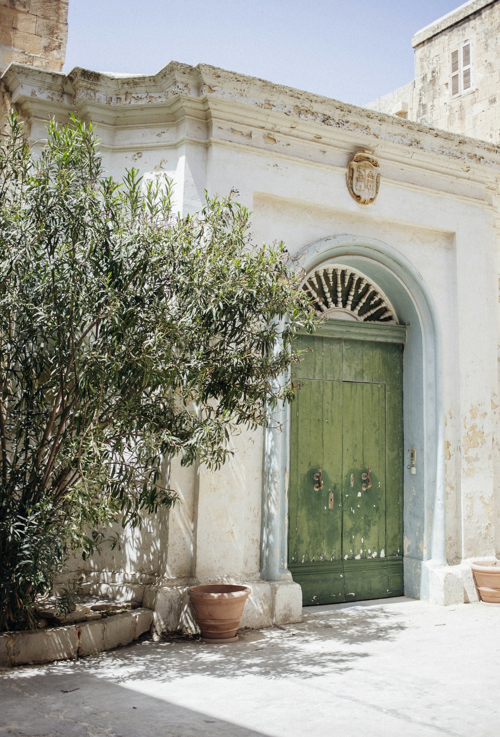 Παραδοσιακή πράσινη ξύλινη πόρτα σε μεσογειακό πέτρινο κτίριο